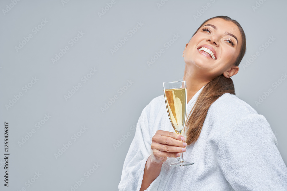 Photo of happy woman in bathrobe over gray background with sparkling wine Photo of happy woman in bathrobe over gray background with sparkling wine