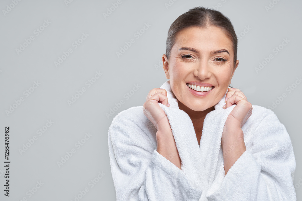 Photo of happy woman in bathrobe over gray background Photo of happy woman in bathrobe over gray background