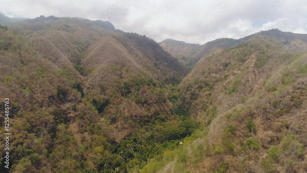 aerial view slopes mountains covered with forest and vegetation against blue sky. mountain hilly landscape in asia. tropical landscape aerial view slopes mountains covered with forest and vegetation against blue sky. mountain hilly landscape in asia. tropical landscape