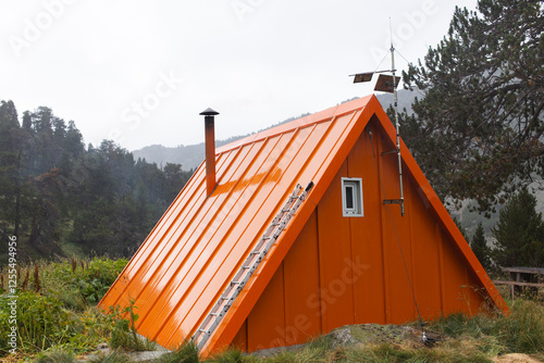 Orange cabin in the Pyrenees mountains of Spain surrounded by nature photo