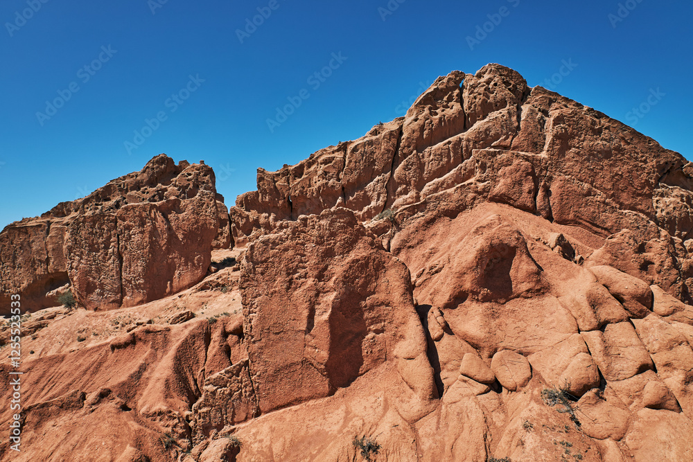 Fototapeta premium Fairy Tale Canyon on the southern shore of Issyk-Kul lake, Kyrgyzstan. Picturesque travel destination, landmark Kirgiziya. Summer skazka canyon with colorful rocks and hills. Natural park landscape