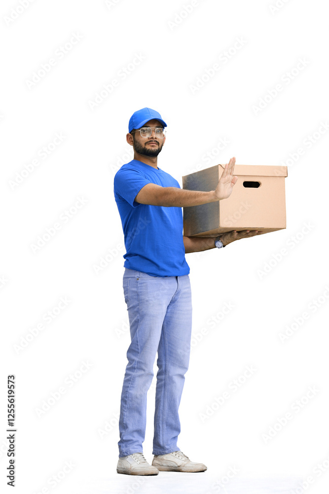 A male deliveryman, on a white background, in full height, with a box, shows a stop sign A male deliveryman, on a white background, in full height, with a box, shows a stop sign