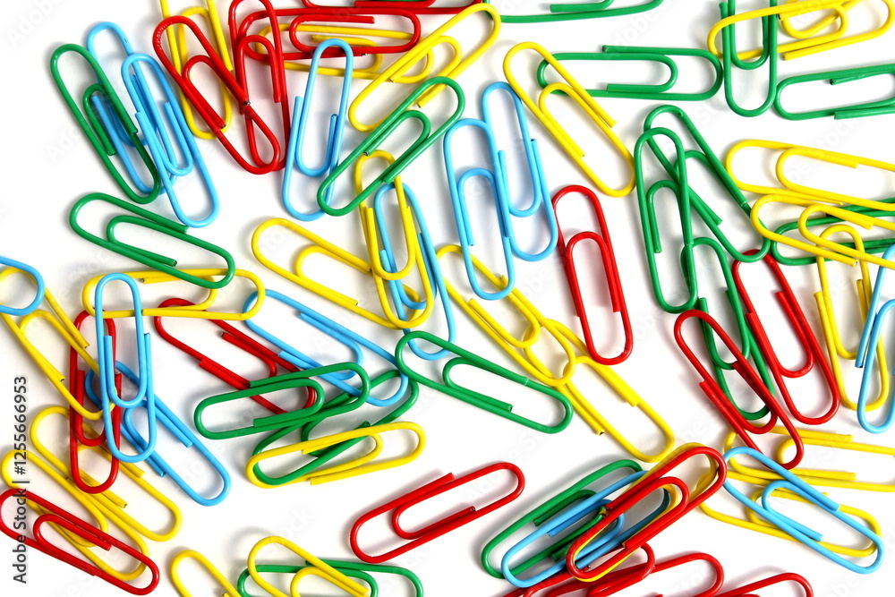 Bright paper clips on a white background. Abstract texture. Bright paper clips on a white background. Abstract texture.