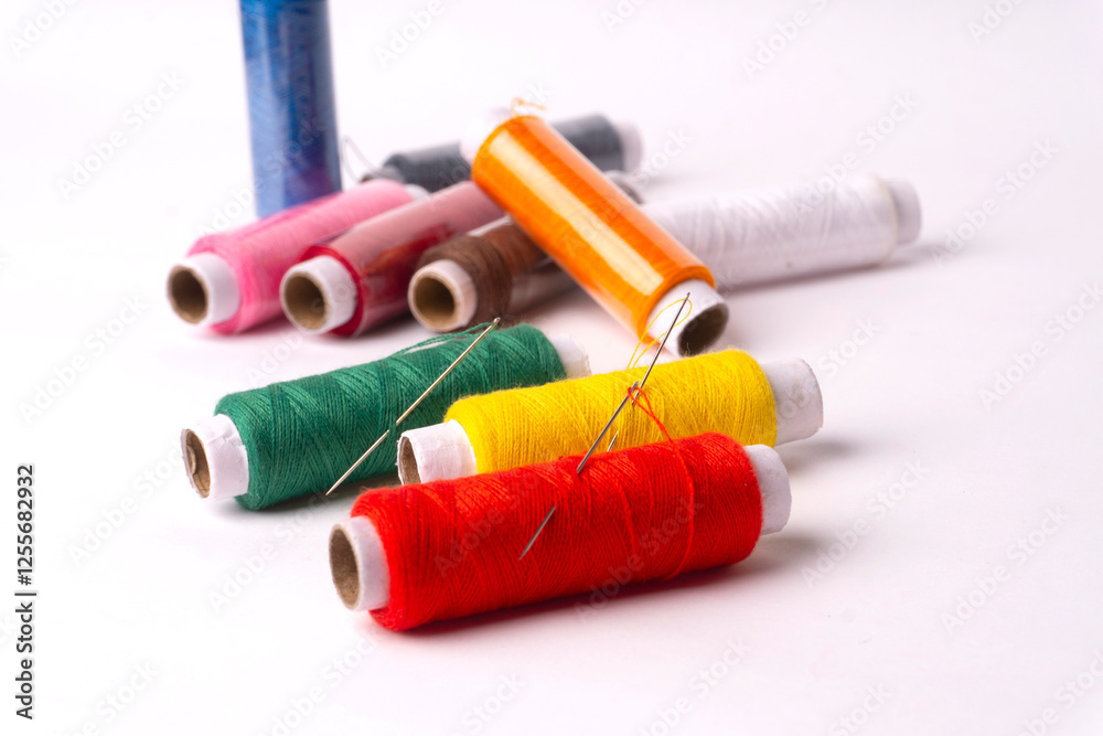 Colorful sewing thread set and needles isolated on background.
Colorful sewing thread set and needles isolated on background.