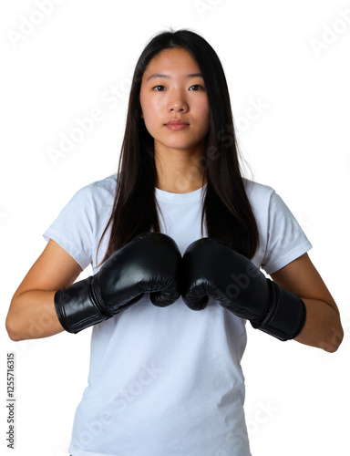 Obraz na płótnie A young woman with long dark hair stands, wearing a white T-shirt and black boxing gloves, against a white background. w salonie