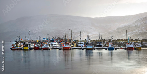 fishing boats in harbor in fog  in a norway village Gjesvaer on Mageroya isla...