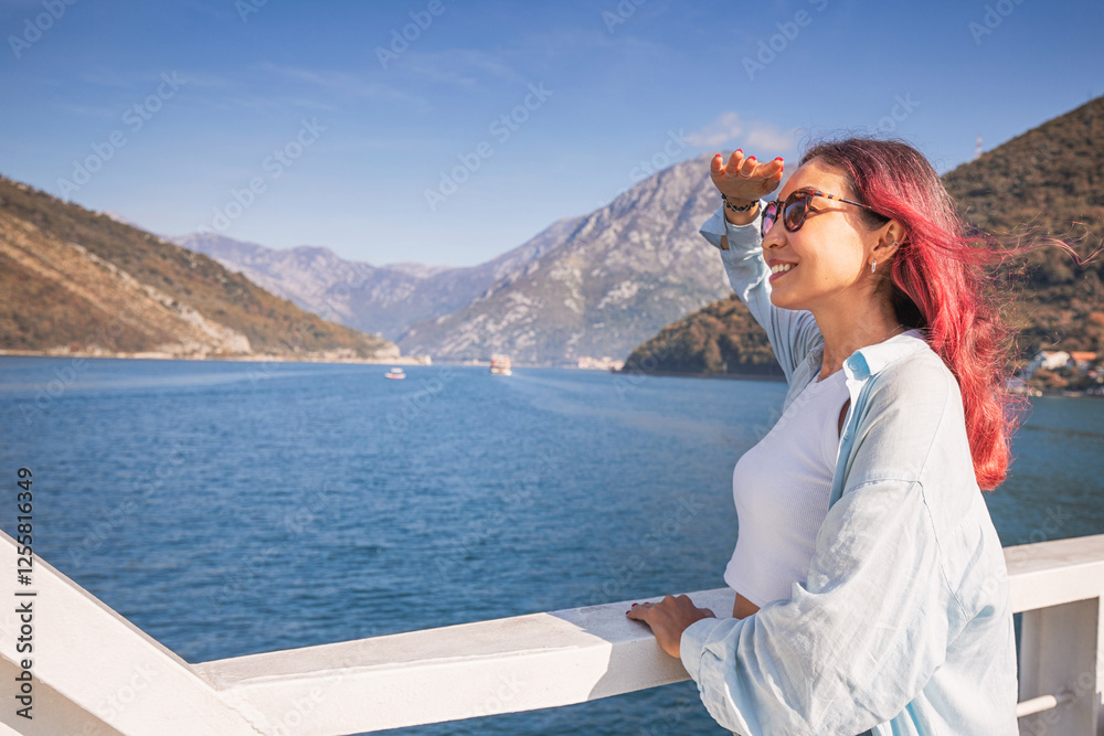 Tourist looking at the horizon while traveling by ferry boat in Montenegro Tourist looking at the horizon while traveling by ferry boat in Montenegro