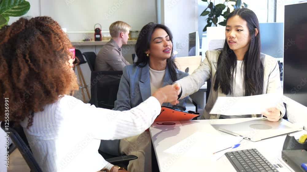 Businesswomen shaking hands after successful agreement in coworking office