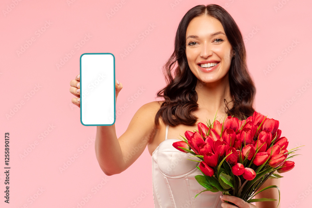 Attractive lady in dress holding bouquet of red tulips and showing blank smartphone screen, woman on spring holiday with flowers on pink background Attractive lady in dress holding bouquet of red tulips and showing blank smartphone screen, woman on spring holiday with flowers on pink background