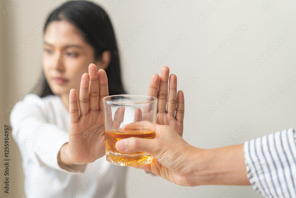 Alcoholism, depressed asian young woman hand refuse alcoholic beverage, drink whiskey while person holding glass give to her. Treatment of alcohol addiction, having suffered abuse problem alcoholism. Alcoholism, depressed asian young woman hand refuse alcoholic beverage, drink whiskey while person holding glass give to her. Treatment of alcohol addiction, having suffered abuse problem alcoholism.