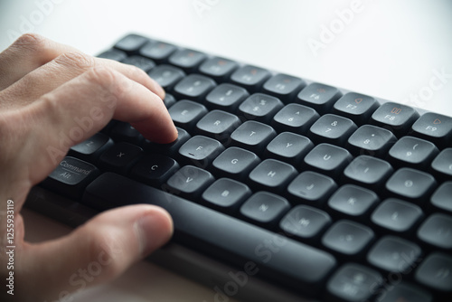 Close up of a man's hands on keyboard of lap top in the dark room, people working at home, modern white notebook. Internet, work, technology concept.