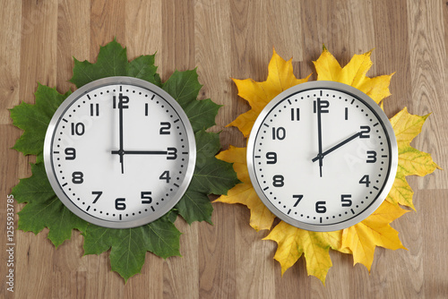 Two Clocks: one showing two o'clock, the other three o'clock. Symbolizing the change from summer to winter time, with green Leaves for summer and yellow for winter. Moving the hands backwards.