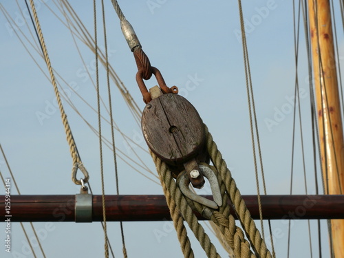 A wooden pulley in a sailing ship's rigging facilitates sail handling. A fascinating detail of traditional maritime engineering.