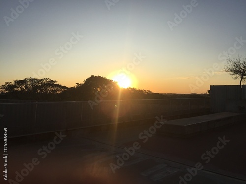 Sunset view from the esplanade of Mineirão Stadium in Belo Horizonte, Minas Gerais, Brazil, with warm light illuminating the horizon and surrounding urban landscape.