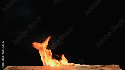 Closeup view of burning wood with fire. Warm wood crackling fireplace with glowing flame on black background
