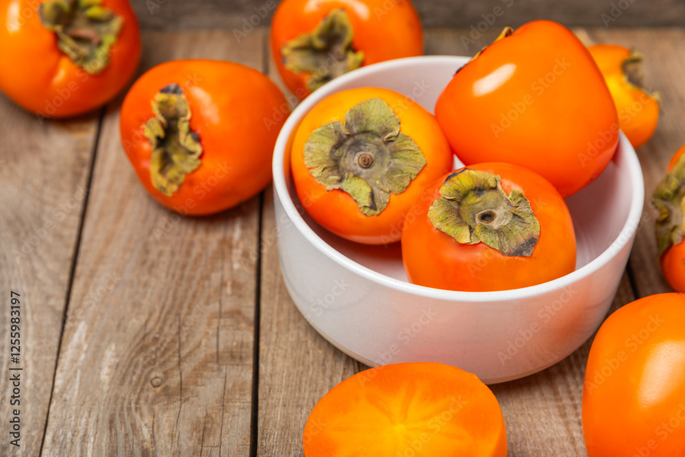 Persimmon on textured wooden background. Persimmon fruit. A piece of ripe, juicy, sweet persimmon fruit. Vegan. Orchard. Close-up. Space for text. Copy space. Persimmon on textured wooden background. Persimmon fruit. A piece of ripe, juicy, sweet persimmon fruit. Vegan. Orchard. Close-up. Space for text. Copy space.