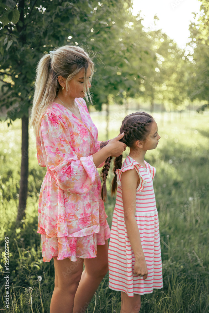Mother Braiding Daughter’s Hair in a Peaceful Outdoor Setting Mother Braiding Daughter’s Hair in a Peaceful Outdoor Setting