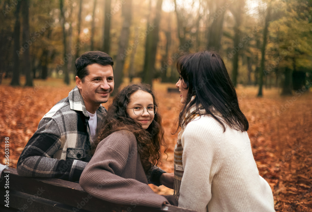 Family enjoys autumn day in scenic park with colorful leaves Family enjoys autumn day in scenic park with colorful leaves