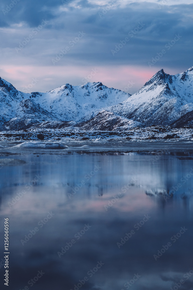 Cloudy sundown sky over snowy mountains located on shore of frozen sea Cloudy sundown sky over snowy mountains located on shore of frozen sea
