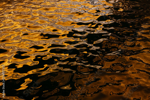 Golden water reflections at Playa Blanca Port, Lanzarote