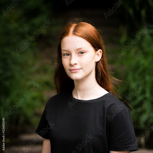 Jette, Brussels, Belgium - Red haired twelve year old girl with freckles posing with a city bokeh background, Jette, Belgium. Model released