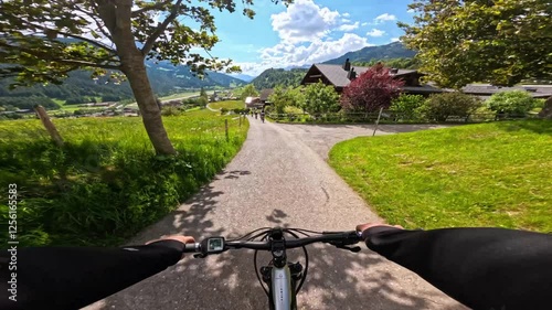 Point of view of a person riding mountain e-bike with scenic mountain view. Freedom concept of a tourist man riding a bicycle on mountain trail. Travel summer activities in Swiss Alps