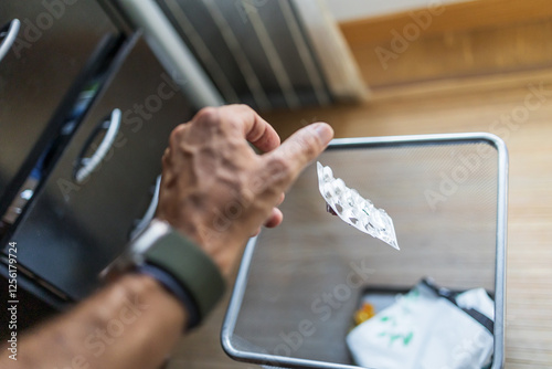 Discarding an Medicine Blister Pack in Waste Bin photo