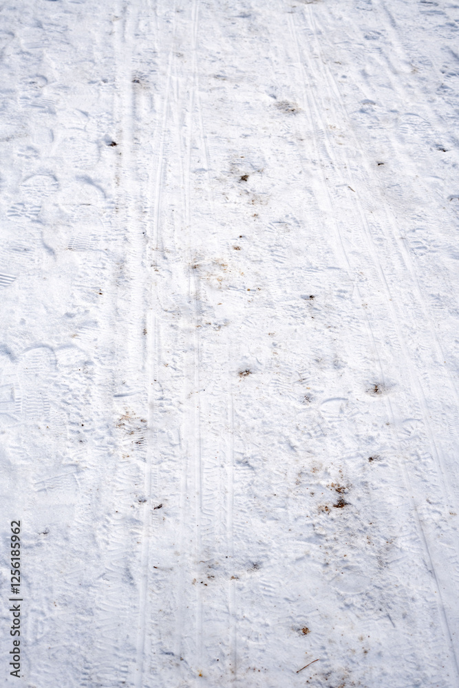 Snow-covered ground with visible footprints and trails, showcasing winter season's backdrop and the texture of ice and snow underfoot, revealing human activity in a snowy landscape. Snow-covered ground with visible footprints and trails, showcasing winter season's backdrop and the texture of ice and snow underfoot, revealing human activity in a snowy landscape.