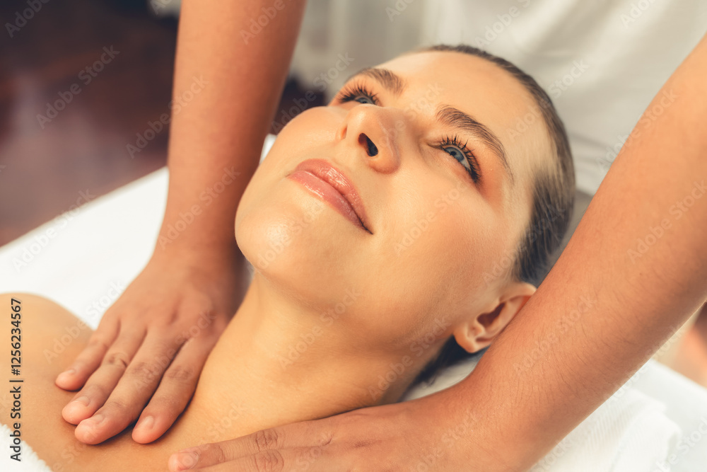 Naklejka premium Caucasian woman customer enjoying relaxing anti-stress spa massage and pampering with beauty skin recreation leisure in day light ambient salon spa at luxury resort or hotel. Quiescent