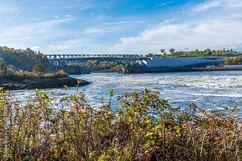 A view over shoreline vegetation of the reversing falls at Saint John, New Brunswick in the fall photo