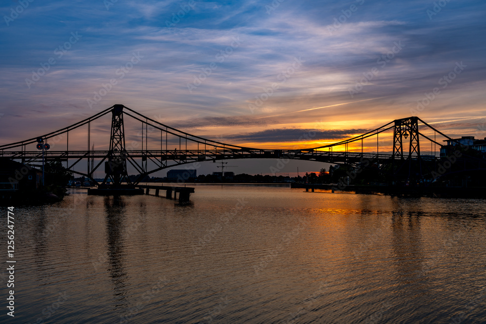 Obraz premium Sonnenuntergang hinter der Kaiser-Wilhelm-Brücke