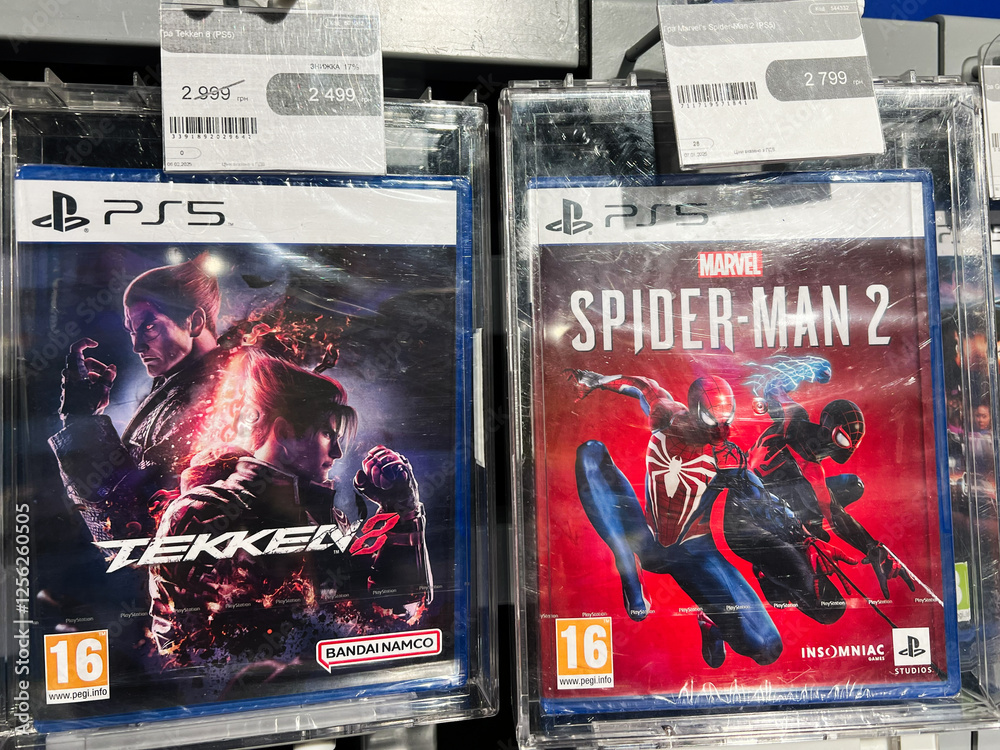 Naklejka premium Kyiv, Ukraine - February 09, 2025: Display of PlayStation 5 game covers for Tekken 8 and Spider Man 2