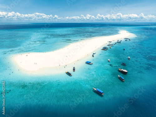 Aerial view of Nakupenda island, sandbank in ocean, white sandy beach, boats, blue sea during low tide at sunny summer day in Zanzibar. Top view of sand spit, clear water, sky with clouds. Tropical