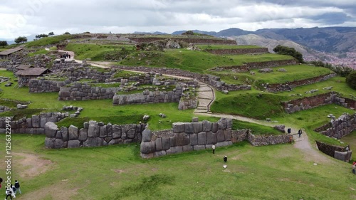 Tourists walking around the sacsayhuaman fortress, an inca archaeological site near cusco, peru