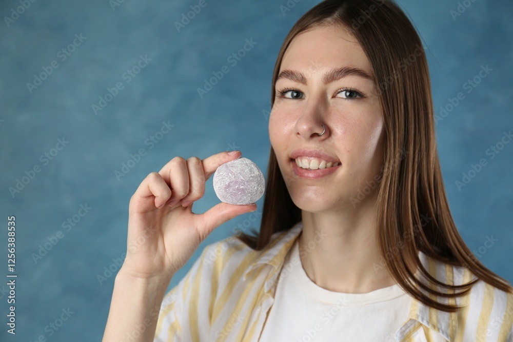 Smiling woman with tasty mochi on blurred blue background. Space for text Smiling woman with tasty mochi on blurred blue background. Space for text