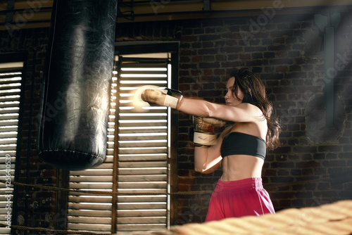 Girl with a punching bag in gloves photo