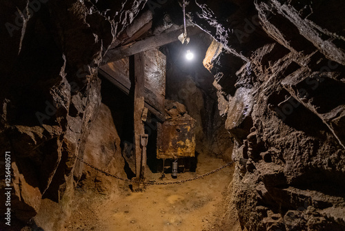 Exploring an abandoned underground mine with rusted equipment and dim lighting, highlighting the remnants of a once-active mining site in a remote location
