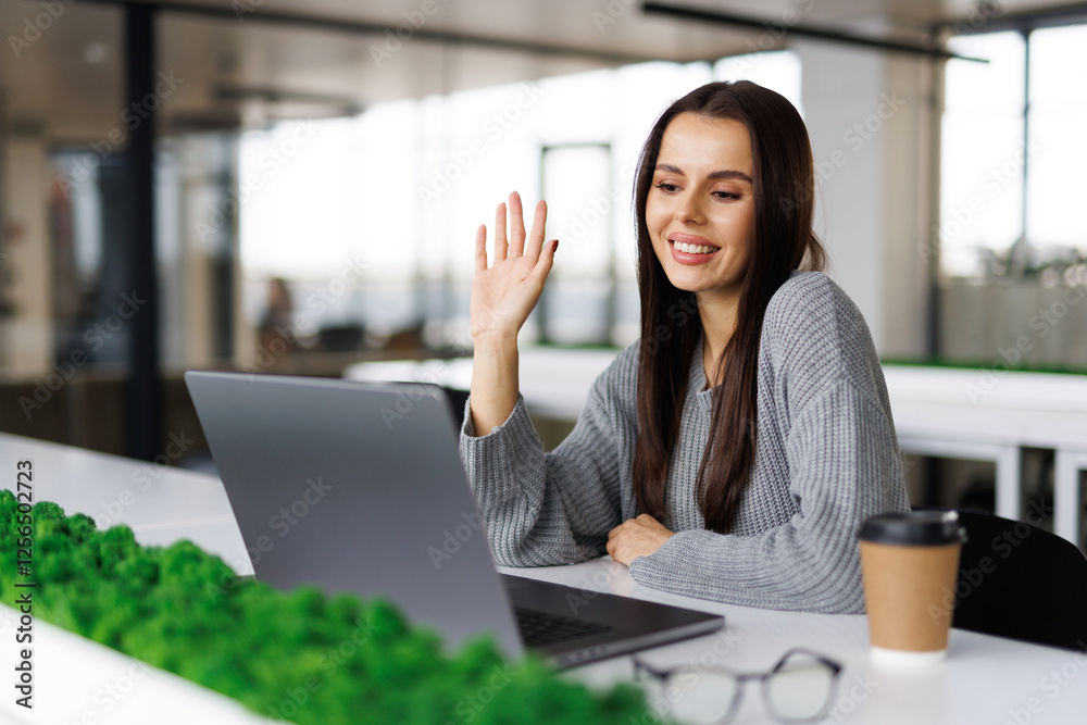 Business woman talking on a video call in a coworking office. Business woman having an online meeting with her team. Business woman talking on a video call in a coworking office. Business woman having an online meeting with her team.