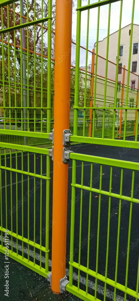 Closed gates on the sports ground.
Bright green metal gate with orange support. Modern fence construction Closed gates on the sports ground.
Bright green metal gate with orange support. Modern fence construction