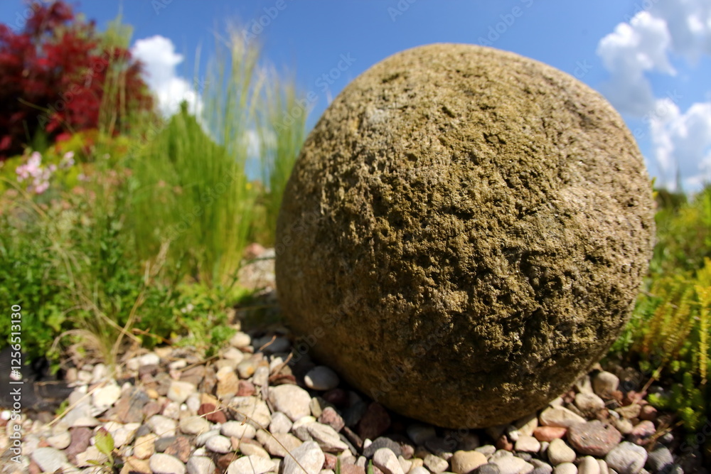 A Ground Stone Sphere positioned elegantly within a serene and natural landscape setting