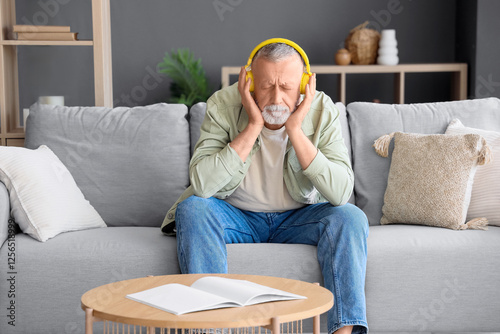 Mature man in headphones li...
