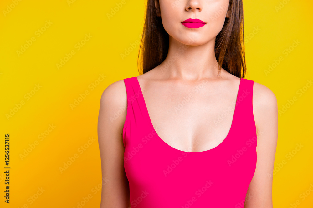 Close up half face portrait of confident brunette woman with red lips in vivid swimsuit isolated on bright yellow background