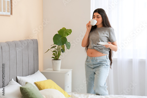 Young pregnant woman drinki...
