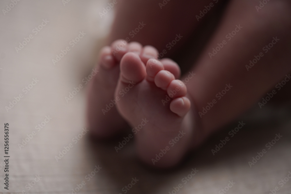 A close-up of newborn baby feet, symbolizing purity, warmth, and the beauty of early life. The soft lighting and neutral tones create a serene and intimate moment of infancy.

