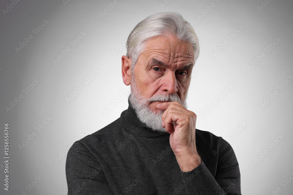 Portrait of confident senior man with silver beard on light grey background Portrait of confident senior man with silver beard on light grey background
