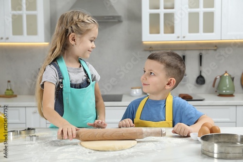 Little helpers. Children making cookies in kitchen at home photo