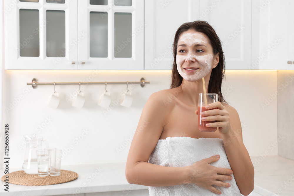 Spa day. Beautiful woman with face mask and juice in kitchen, space for text Spa day. Beautiful woman with face mask and juice in kitchen, space for text