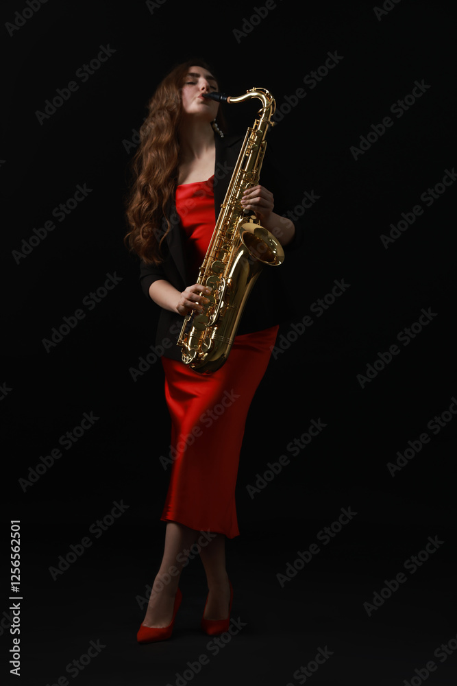 Obraz premium Professional musician playing saxophone on black background