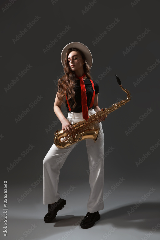 Naklejka premium Professional musician with saxophone on grey background