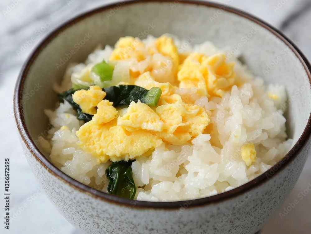 Cooked rice with egg and vegetables in a bowl. Steamed white rice mixed with egg and vegetables in a ceramic bowl. Emphasizing protein and savory flavor. Ideal for food blogs and quick meals. Cooked rice with egg and vegetables in a bowl. Steamed white rice mixed with egg and vegetables in a ceramic bowl. Emphasizing protein and savory flavor. Ideal for food blogs and quick meals.